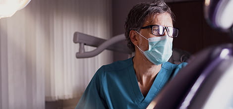 Dentist in his practice next to an empty treatment chair